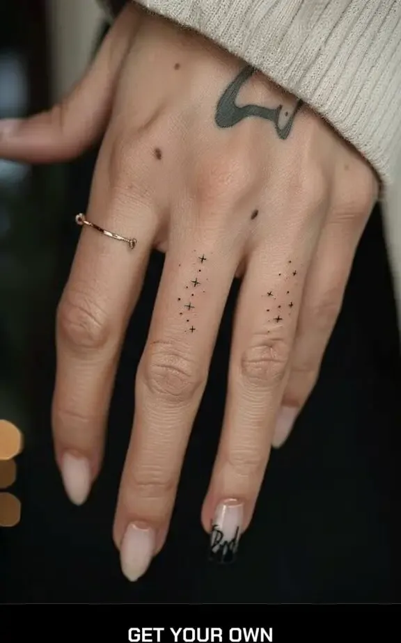 dots and stars tattoo on the finger